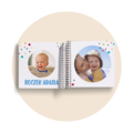 Otwarta fotoksiążka dla dzieci na spirali, z kolorowymi kropkami. Po lewej zdjęcie Adasia, po prawej z mamą. Napis: Roczek Adasia.