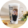 Personalizowany kubek latte z nadrukiem zdjęcia dziecka i napisem Kubek Szefowej stoi na stole obok kwiatów i ciasteczek
