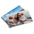 Dwa wydrukowane zdjęcia, na wierzchu rodzina z dwójką dzieci na plaży, w tle fotografia błękitnego nieba