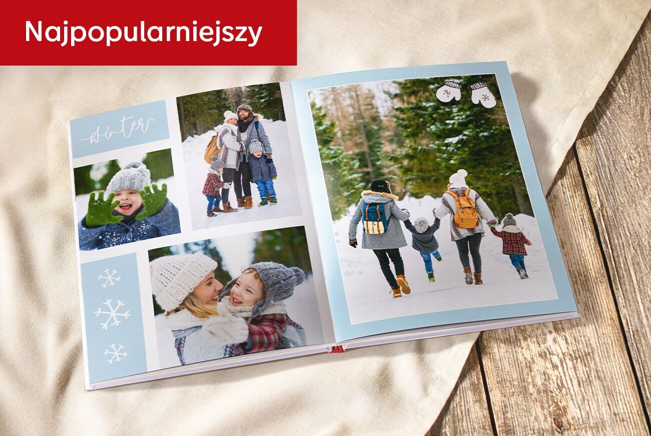 Otwarta fotoksiążka z zimowymi zdjęciami rodziny; leży na tkaninie i drewnianym blacie. W rogu czerwony pasek z napisem Najpopularniejszy